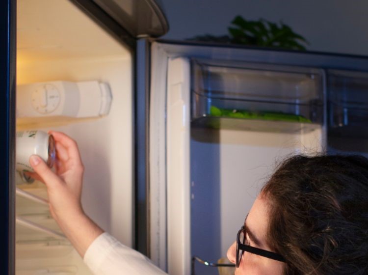 Checking fridge temperature with a thermometer